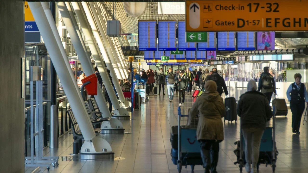people walking through a wide airport check-in hall