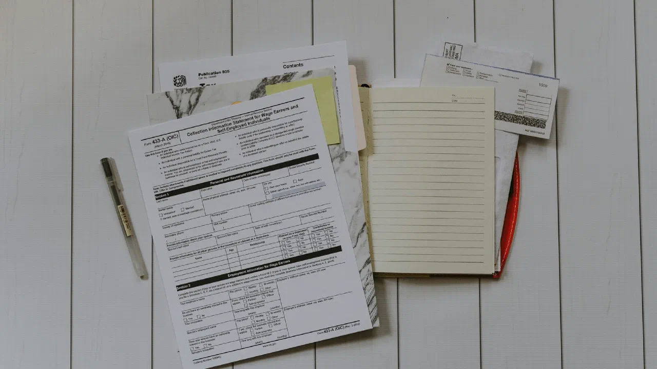 an overhead view of a stack of loose papers on a desk